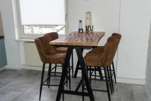 Hochstetten-DhaunFerienhaus Laila的餐桌、四把椅子、一张桌子和一张棋盘桌