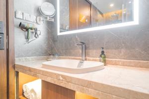 上海时光漫步S酒店（上海五角场店）的浴室的柜台设有水槽和镜子