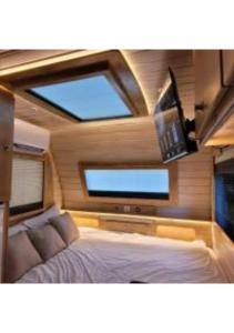 哈德内斯Helios Luxury Caravan's的一间卧室配有一张床和一台平面电视