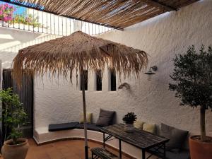阿瓜阿马加Casa Nomad es su hogar mágico en Agua Amarga的一个带桌子和草伞的庭院