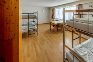 英格堡Engelberg Youth Hostel的宿舍间设有双层床、桌子和书桌。