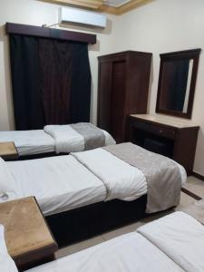 艾卜哈Basma Plaza的酒店客房,设有三张床和镜子