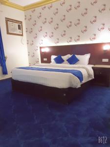 艾卜哈Basma Plaza的一间卧室配有一张大床,铺有蓝色地毯