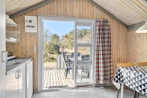 斯卡恩First Camp Råbjerg Mile - Skagen的厨房设有滑动玻璃门,可通往庭院。