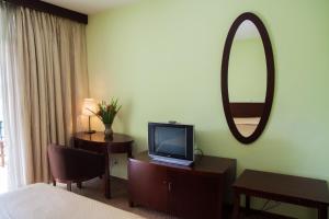 鲁亨盖里Gorillas Volcanoes Hotel的酒店客房带电视和镜子