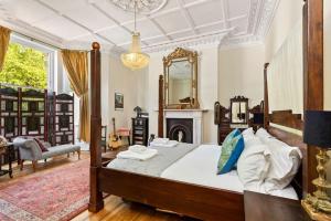 HollingtonLuxurious Victorian, a few minutes from the beach的一间卧室设有一张大床和一个壁炉