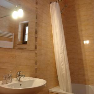 坎普-杜热雷什Bungalows - Serra do Gerês的浴室配有盥洗盆、镜子和浴缸