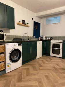 埃文河畔布拉德福'Downtown' @ Terracotta Court的厨房配有绿色橱柜、洗衣机和烘干机