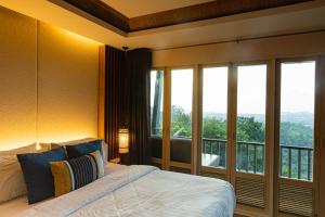 查龙Phuket View Coffee and Resort的一间卧室设有一张床和一个大窗户