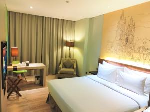 雅加达AONE酒店的酒店客房配有一张床、一张桌子和一把椅子。