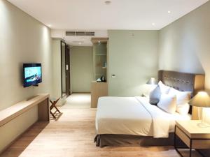 雅加达AONE酒店的一间酒店客房,配有一张床和一台电视