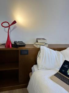 圣卡特琳娜瓦尔夫Hotel Alle Tre Baite的一张带红灯的床和一台笔记本电脑