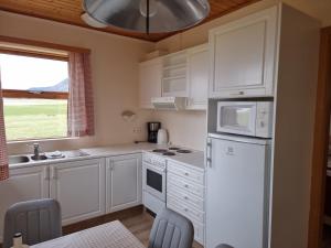 霍夫Litla-Hof Guesthouse的厨房配有白色橱柜和白色冰箱。
