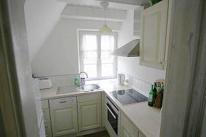 于克里茨Haus am Achterwasser Whg "Klabautermann"的白色的厨房设有水槽和窗户