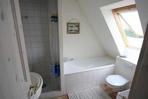 于克里茨Haus am Achterwasser Whg "Klabautermann"的带浴缸、卫生间和盥洗盆的浴室