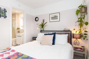 Tile HillDetached house with Netflix, gym, garden, BBQ, coffee and more的一间卧室配有带白色床单和蓝色枕头的床。