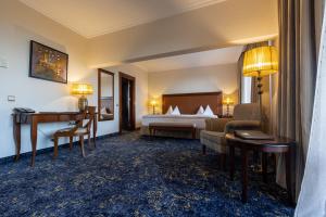布尔加斯普利莫雷兹格兰德Spa酒店的配有一张床和一张书桌的酒店客房