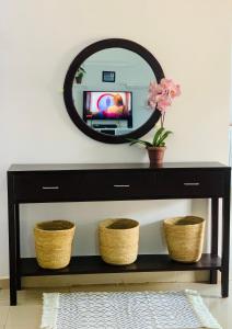伊林加Winnie's Cozy Home的黑色控制台上方的镜子,带篮子