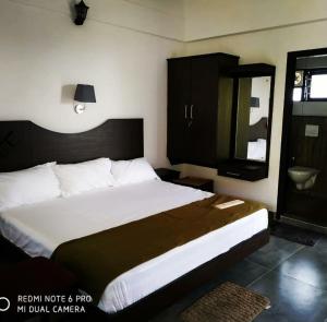 PadinjaratharaZadokz farmstay的卧室配有一张白色大床和镜子