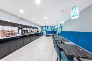 史普林维尔史普林维尔戴斯酒店的餐厅设有木桌和蓝色的墙壁