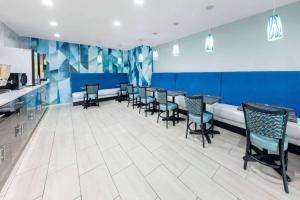 史普林维尔史普林维尔戴斯酒店的一间配备有桌椅的用餐室和蓝色的墙壁