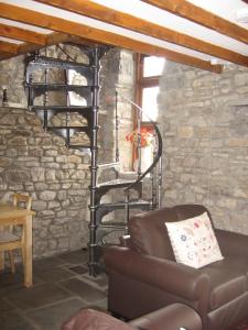 阿伯代尔Tunnel Cottages at Blaen-nant-y-Groes Farm的客厅设有螺旋楼梯,位于石墙内