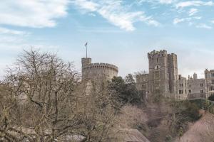 温莎Hidden Gem With Windsor Castle Views & Parking的一座山丘上的城堡,前面有树木
