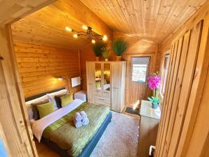 普里茅斯Yealm Cabin Self Catering Log Cabin in Devon with Hot Tub的小木屋内一间卧室,配有一张床