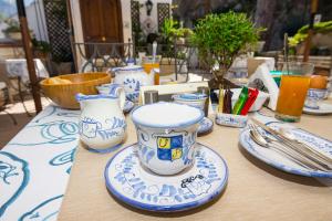 波西塔诺Villa Palumbo的一张桌子上放着蓝白杯子和盘子