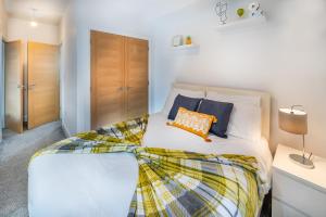雷丁Modern & spacious 2-bed flat with secure parking的卧室配有带橙色枕头的大型白色床