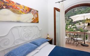 波西塔诺Villa Palumbo的一间卧室设有一张床,享有阳台的景色