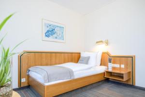 索林根Select Hotel Solingen的一张带木制床头板的床