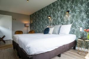 德科克斯多普Hotel het Anker van Texel的一间卧室设有一张大床和绿色的墙壁
