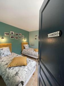 ThenayGîte La Cabuche proche du zoo de Beauval的绿墙客房内的两张床