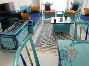 拉马萨Marsa Central Splendid Appart 2的客厅配有蓝色的家具和桌子