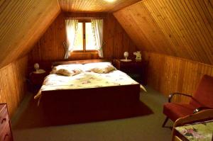 DoubiceChata Doubice的木制客房内的一间卧室,配有一张床