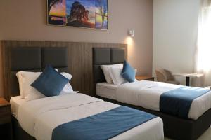 利雅德فندق منار بارك的酒店客房 - 带两张带蓝色枕头的床
