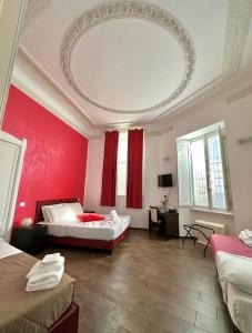 罗马首都神殿旅馆的一间设有两张床和红色墙壁的客房