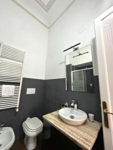 罗马首都神殿旅馆的一间带水槽、卫生间和镜子的浴室