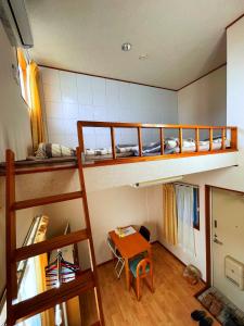 埼玉市大宮溫馨小屋的客房设有两张双层床和一张桌子。