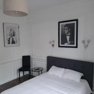 里摩日Hôtel Les Beaux Arts- Limoges Hypercentre的一间卧室配有一张床,并拥有黑白照片