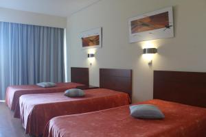 蒙考Hotel Dom Afonso - Monção的酒店客房,配有两张带红色床单的床
