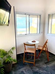 海法Sea view cozy apartment的窗户客房内的桌椅