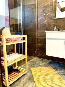 海法Sea view cozy apartment的带淋浴、水槽和书架的浴室