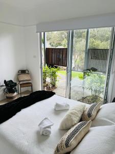 BomaderryURALLA STUDIO - South Coast - Private Guest Suite的卧室配有白色的床和枕头。