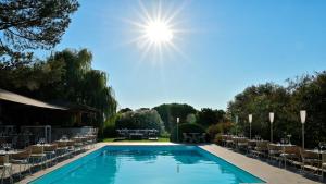 普罗普里亚诺巴塔西亚酒店的一个带椅子的游泳池,阳光在天空中
