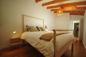 维拉·诺瓦·达·塞尔维尔Casas de Santiago的一间带一张大床的卧室,位于一个拥有木制天花板的房间