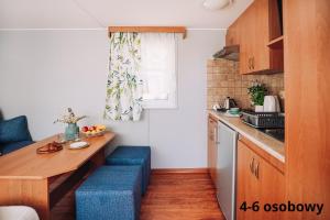 德布吉Słoneczne domki的一个带木桌和蓝色凳子的小厨房