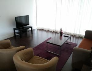 尼科西亚卡皮塔尼公寓的客厅配有两把椅子、一张桌子和电视