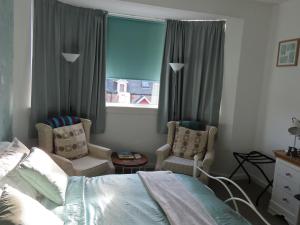 因弗内斯Alba b & b的一间卧室配有一张床、两把椅子和一个窗户
